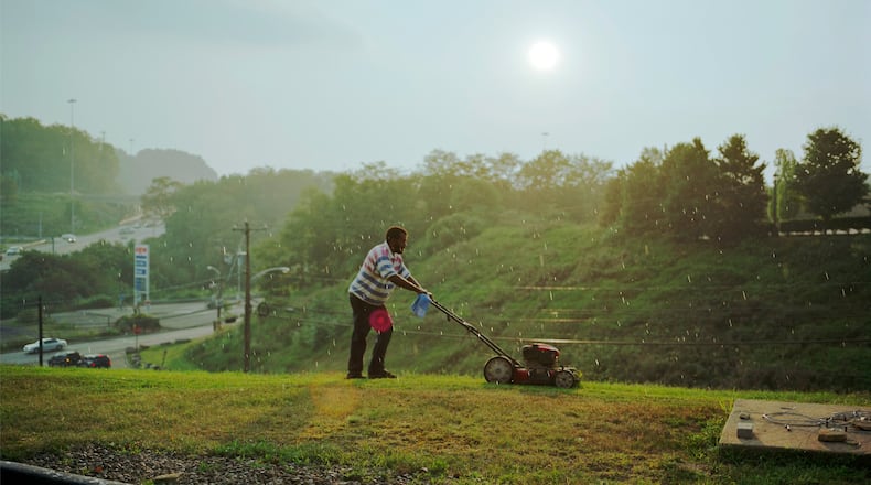 Paul Graham’s “Pittsburgh (detail)” captures the typically overlooked effort of a man mowing the grass on a steep hillside at a generic highway exit of cheap motels and gas stations. COPYRIGHT PAUL GRAHAM / CONTRIBUTED BY PACE/MACGILL GALLERY, NEW YORK