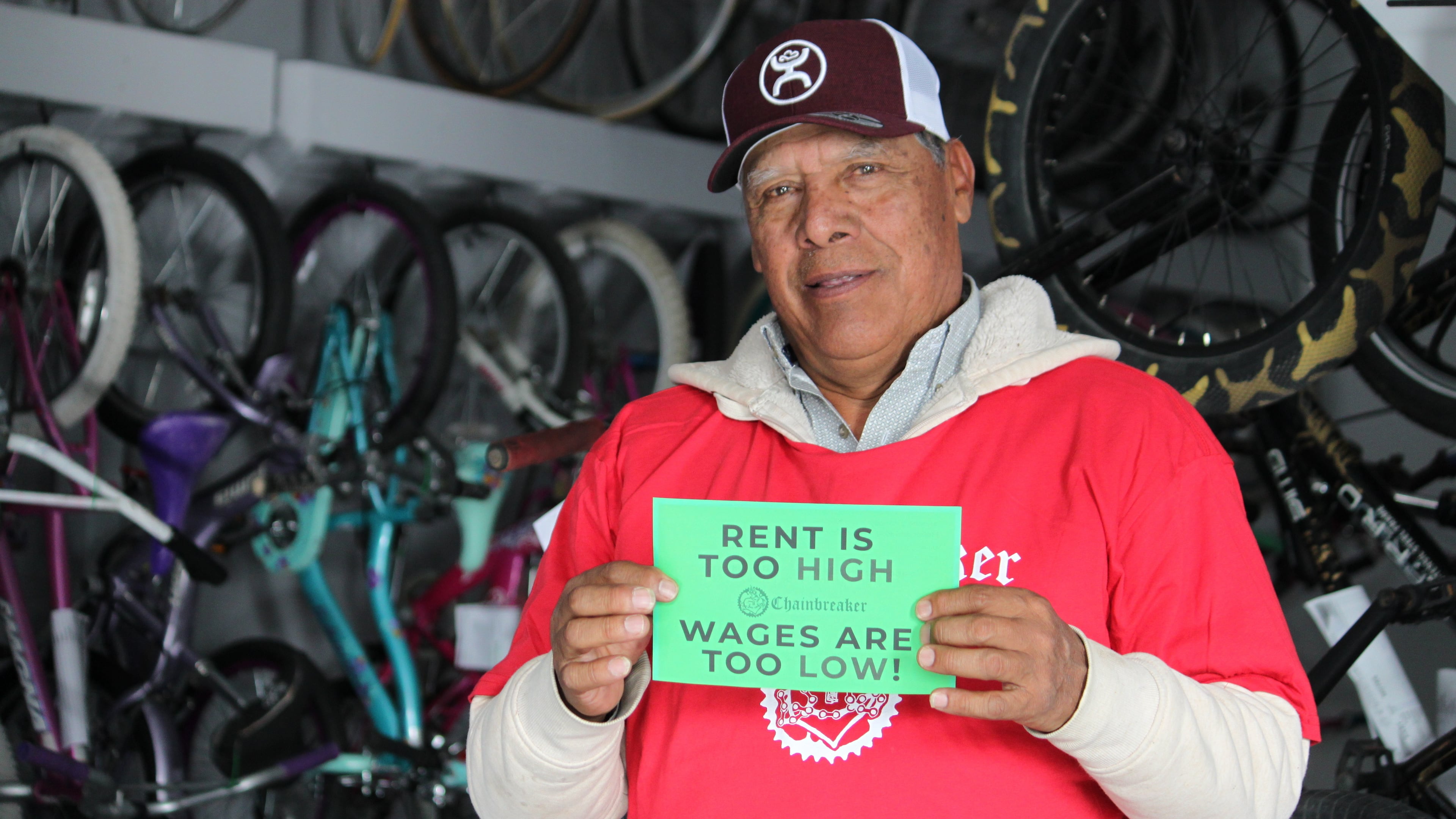 Ismael Cortes Estrada poses for a photo holding one of the signs advocates used in the campaign for updating the city's minimum wage law, in Santa Fe, New Mexico, on Wednesday, Nov. 26, 2025. (AP Photo/Susan Montoya Bryan)