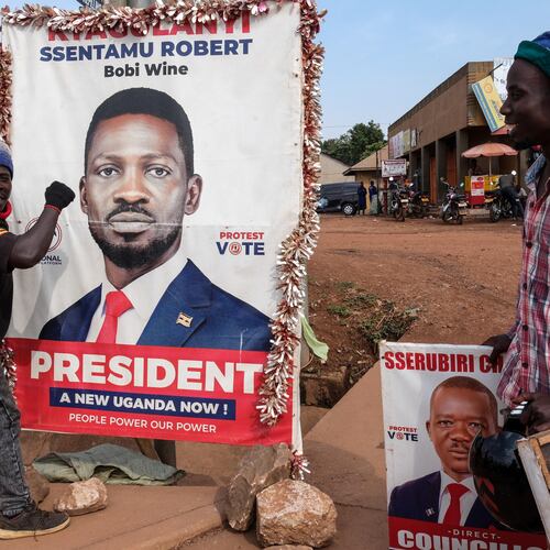 A supporter of Uganda opposition presidential candidate Robert Kyagulanyi Ssentamu, known as Bobi Wine, holds onto a campaign poster in Kampala, Uganda, Tuesday, Jan. 13, 2026. (AP Photo/Hajarah Nalwadda)