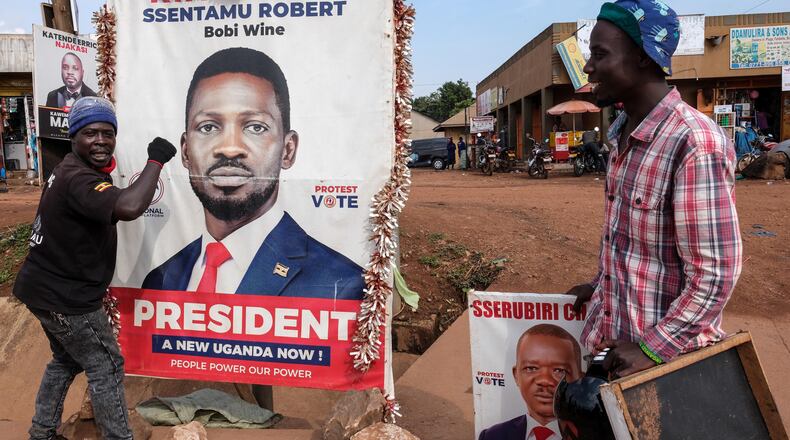 A supporter of Uganda opposition presidential candidate Robert Kyagulanyi Ssentamu, known as Bobi Wine, holds onto a campaign poster in Kampala, Uganda, Tuesday, Jan. 13, 2026. (AP Photo/Hajarah Nalwadda)