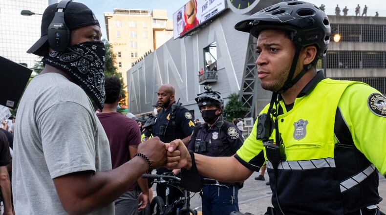 200603-Atlanta-Atlanta Police Officer Brandon Hayes fist bumps a demonstrator Wednesday evening June 3 in Downtown Atlanta after explaining that he became a police officer after Trayvon Martin was killed because he wanted to make a difference. Ben Gray for the Atlanta Journal-Constitution