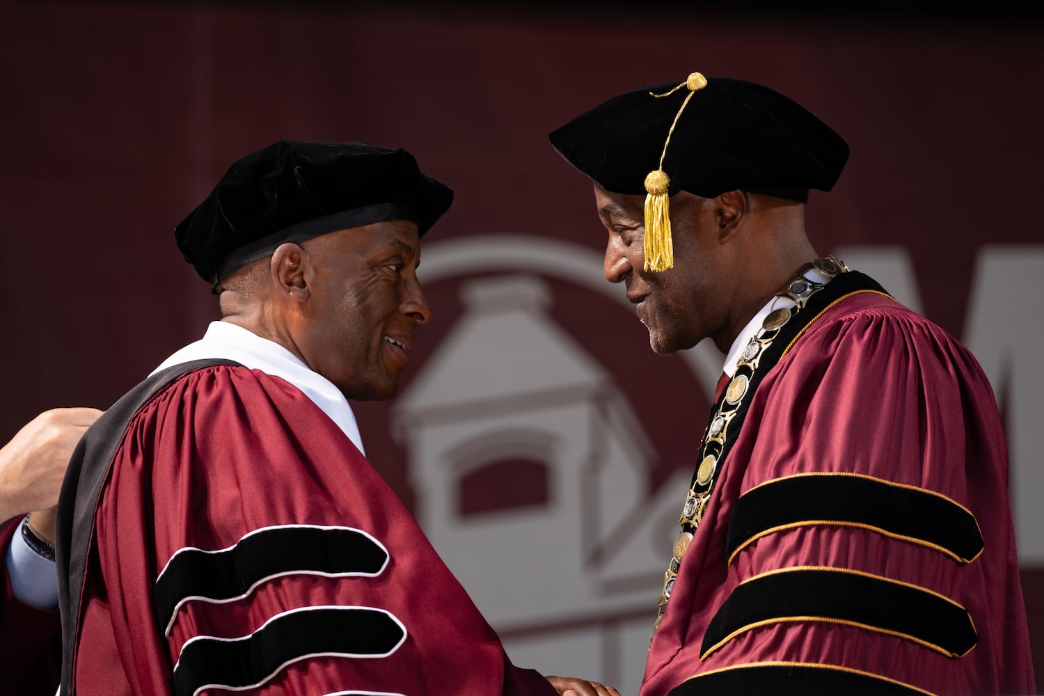Christopher Womack (left), chairman, president and CEO of Southern Company, shakes hands with Morehouse College President F. DuBois Bowman after receiving an honorary Doctor of Humane Letters during graduation Sunday, May 17, 2026. (Ben Gray for the AJC)