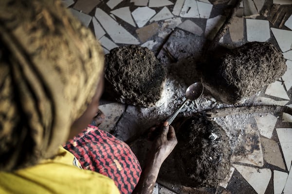 Without using protective equipment, Sadio Camara, a gold processor, vaporizes mercury to separate and retrieve gold at her home in the Kedougou region of Senegal on Thursday, Jan. 16, 2025. (AP Photo/Annika Hammerschlag)