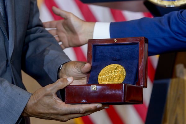 House Speaker Mike Johnson, R-La., right, presents the Congressional Gold Medal to Stanley Earley III, son of Lt. Col. Charity Adams Earley, left, during a ceremony honoring the Six Triple Eight, on Capitol Hill, Tuesday, April 29, 2025, in Washington. The U.S. Army's 6888th Central Postal Directory Battalion, also known as the Six Triple Eight, was a group of Black servicewomen, serving overseas, to sort millions of pieces of mail and deliver them to the troops in the field of battle during World War II. (AP Photo/Rod Lamkey, Jr.)
