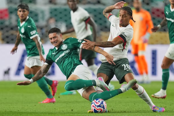 Palmeiras' Emiliano Martinez, left, falls challenged by Chelsea's Joao Pedro during the Club World Cup quarterfinal soccer match between Palmeiras and Chelsea in Philadelphia, Friday, July 4, 2025. (AP Photo/Chris Szagola)
