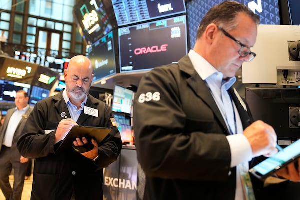 Federico DeMarco, left, and Ed Curran work on the floor at the New York Stock Exchange in New York, Wednesday, July 16, 2025. (AP Photo/Seth Wenig)