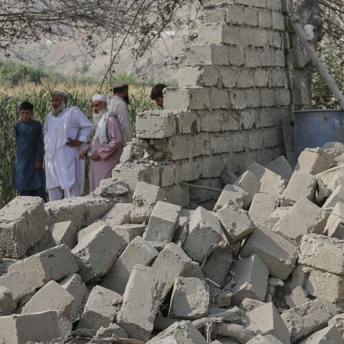 Residents stand near a collapsed wall of a house damaged in a strike in Patan village, Kunar province, eastern Afghanistan, Monday, Sept. 21, 2026. (AP Photo/Shafiullah Kakar)