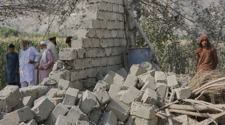 Residents stand near a collapsed wall of a house damaged in a strike in Patan village, Kunar province, eastern Afghanistan, Monday, Sept. 21, 2026. (AP Photo/Shafiullah Kakar)