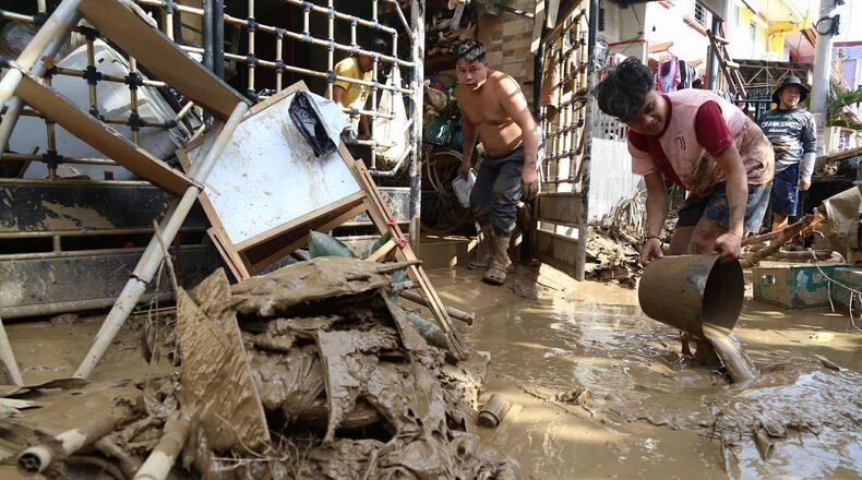 Residents clean up outside their homes after Typhoon Kalmaegi caused devastation in communities at Talisay City, Cebu province, central Philippines, Wednesday, Nov. 5, 2025. (AP Photo/Jacqueline Hernandez)