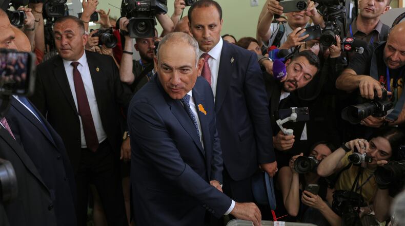 Armenian Prime Minister Nikol Pashinyan, center, casts his ballot at a polling station during the parliamentary election in Yerevan, Armenia, Sunday, June 7, 2026. (AP Photo/Anthony Pizzoferrato)
