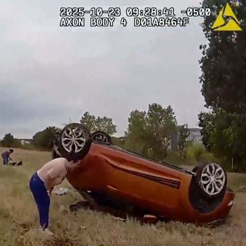 This image taken from video released by the Fort Worth Police Department shows officers responding to an overturned car before pulling a baby out from underneath Thursday, Oct. 23, 2025, in Fort Worth, Texas. (Fort Worth Police Department via AP)