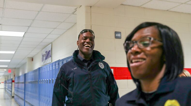 04/17/2018 -- Sandy Springs, GA - Riverwood International Charter School police officer Donald Rene, left, and Fulton County School Police Detective Angela Washington, right, share a laugh while walking the halls of Riverwood International Charter School in Sandy Springs, Tuesday, April 17, 2018. ALYSSA POINTER/ALYSSA.POINTER@AJC.COM