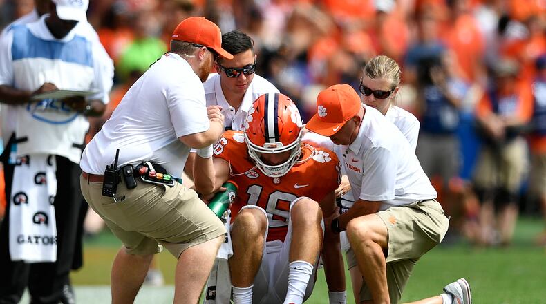 Quarterback Trevor Lawrence #16 of the Clemson Tigers is helped from the field after taking a hard hit from the Syracuse Orange during the football game at Clemson Memorial Stadium on September 29, 2018 in Clemson, South Carolina. (Photo by Mike Comer/Getty Images)