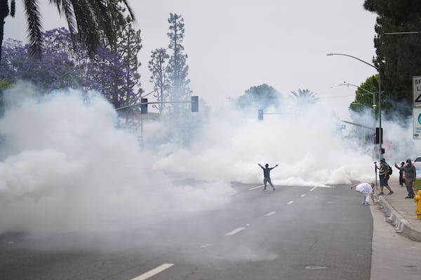Smoke fills the street as protesters confront Border Patrol personnel during a demonstration in the Paramount section of Los Angeles on Saturday, June 7, 2025 (AP Photo/Eric Thayer)