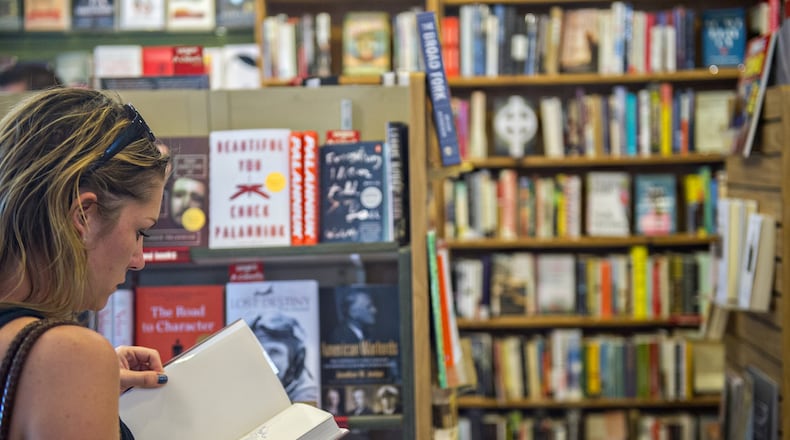 Katie Ellis thumbs through a book at A Cappella bookstore in Atlanta, a local staple for decades. An estimated 15,000 self-help books are published each year in the U.S. The challenge is finding a self-help strategy that fits.  (Jonathan Phillips for The Atlanta Journal-Constitution)