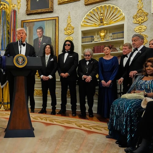 President Donald Trump, center, speaks as he presents Sylvester Stallone, George Strait, KISS, Gloria Gaynor and Michael Crawford with their Kennedy Center Honors medals in the Oval Office of the White House, Saturday, Dec. 6, 2025, in Washington. (AP Photo/Julia Demaree Nikhinson)