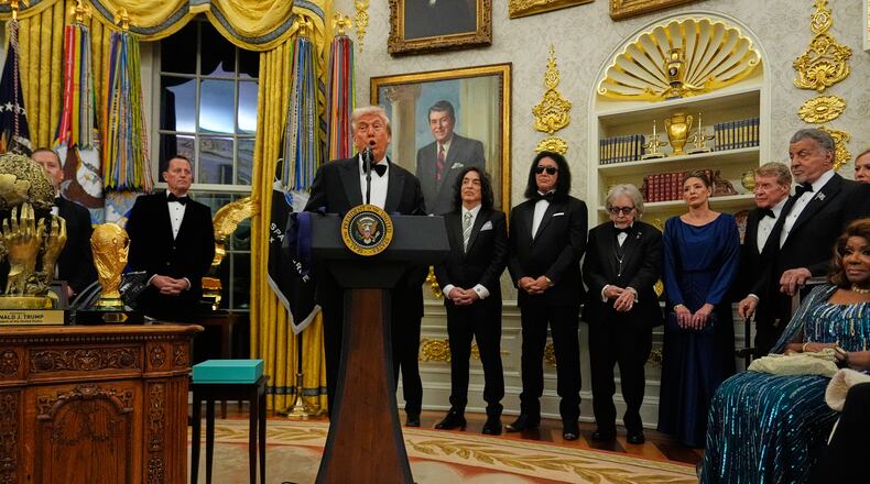 President Donald Trump, center, speaks as he presents Sylvester Stallone, George Strait, KISS, Gloria Gaynor and Michael Crawford with their Kennedy Center Honors medals in the Oval Office of the White House, Saturday, Dec. 6, 2025, in Washington. (AP Photo/Julia Demaree Nikhinson)