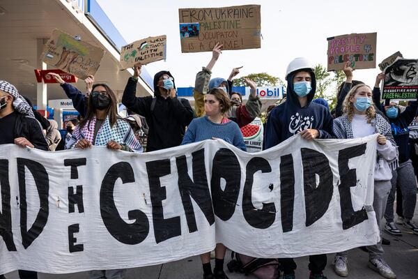 FILE - Chicago police officers keep watch as protesters rally on Fullerton Avenue while crews disassemble the pro-Palestinian encampment in the quad at DePaul University's Lincoln Park campus in Chicago, May 16, 2024. (Ashlee Rezin/Chicago Sun-Times via AP, file)