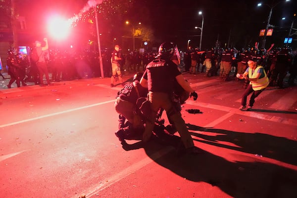 Riot police detain a man after charging protesters at the end of an anti-government rally pressing for an early election after nearly eight months of almost daily anti-corruption demonstrations that have shaken the populist government of President Aleksandar Vucic, in Belgrade, Serbia, Saturday, June 28, 2025. (AP Photo/Darko Vojinovic)