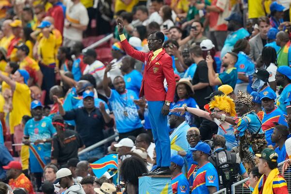 Congo supporter Michel Nkuka Mboladinga poses as a statue of the country’s assassinated independence hero Patrice Lumumba ahead of the group stage match between Colombia and Congo in Mexico.  (Fernando Llano/AP)