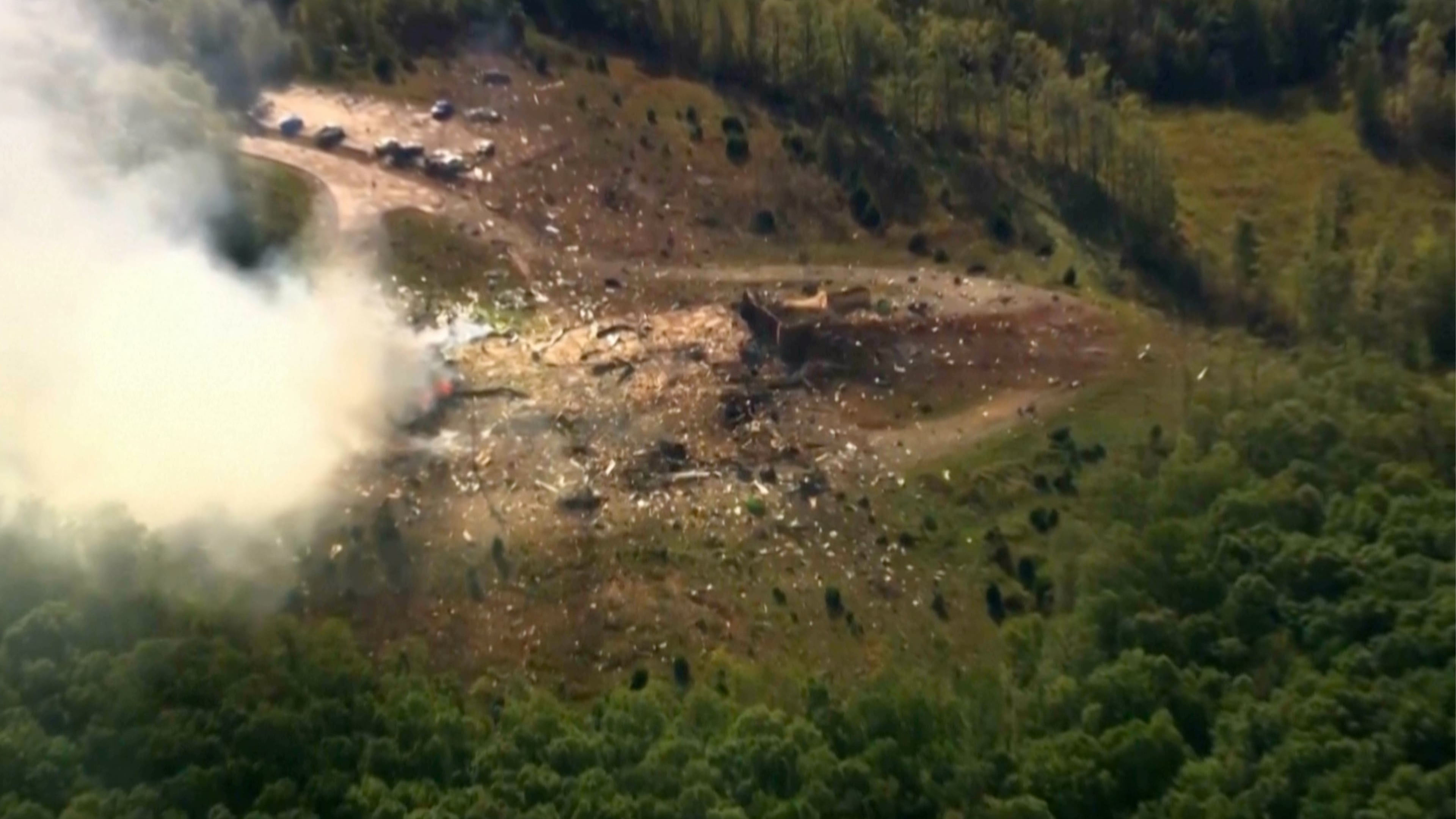Smoke fills the air as debris covers the ground and vehicles after a powerful blast ripped through a military explosives manufacturing plant in Hickman County, Tenn., on Friday, Oct. 10, 2025. (WTVF-TV via AP)