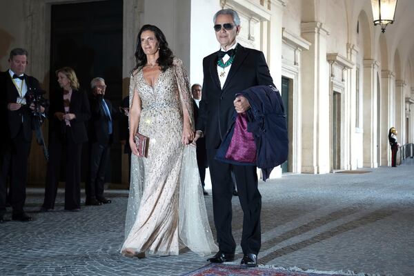 Tenor Andrea Bocelli, right, poses with his wife Veronica Berti as they arrive for an official dinner with King Charles III and Queen Camilla at the Quirinale Presidential Palace to meet with Italy's President Sergio Mattarella, in Rome, Wednesday, April 9, 2025. (AP Photo/Andrew Medichini)