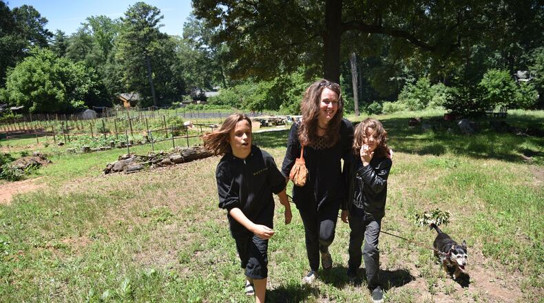 Laurel Snyder and her sons Mose (left), 11, and Lewis, 10, with their dog Lucy visit Red’s Farm in their East Atlanta neighborhood (Ormewood Park). Though Snyder is a successful children’s author, she’ll also say her No. 1 achievement and role is a being a mom to her two sons. HYOSUB SHIN / HSHIN@AJC.COM