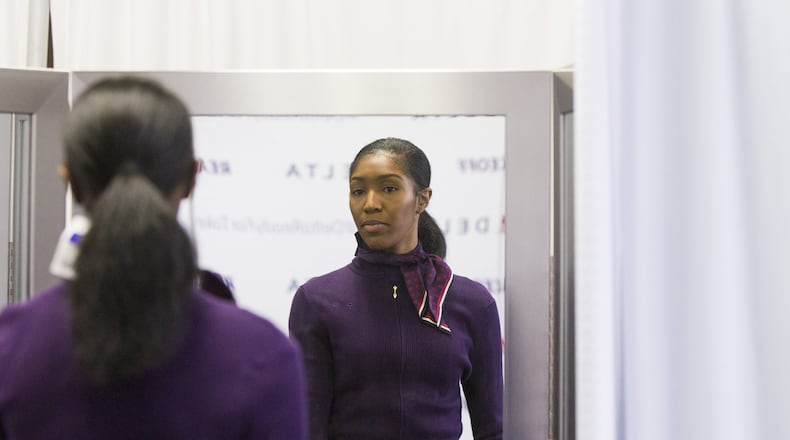 Kyandra Ravenel, a Delta airlines flight attendant, looks at herself in a mirror during the uniform fitting for Delta employees at Hartsfield-Jackson Atlanta International Airport in Atlanta, Georgia, on Wednesday, February 7, 2018. (REANN HUBER/FILE)