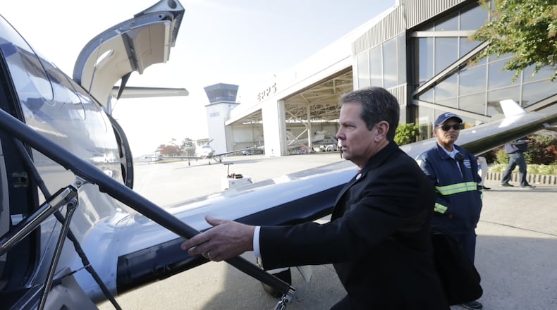 Georgia Secretary of State Brian Kemp boards a plane Monday morning at Peachtree-DeKalb Airport, kicking off a statewide tour ahead Tuesday’s Election Day. BOB ANDRES/ BANDRES@AJC.COM