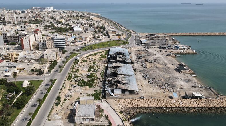 Backdropped by ships in the Strait of Hormuz, damage, according to local witnesses caused by several recent airstrikes during the U.S.-Israel military campaign, is seen on a fishing pier in the port of Qeshm island, Iran, Monday, April 13, 2026. (AP Photo/Asghar Besharati)