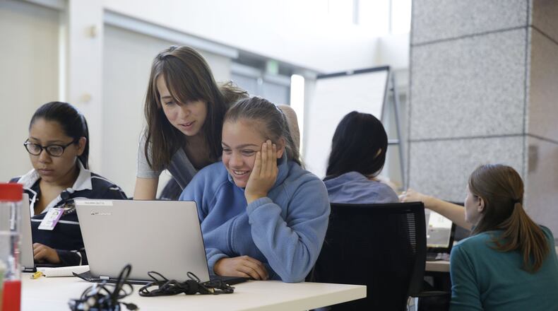 In this photo taken Wednesday, June 18, 2014, teacher assistant Margarita Sokolova, second from left, helps Giuliana Zautta, 17, of Menlo Park, Calif., during a Girls Who Code class at Adobe Systems in San Jose, Calif. Girls Who Code, a national non-profit organization that aims to inspire, educate and equip young women for futures in the computing-related fields, kicked off its summer program in partnership with the world’s leading tech companies. The summer program will reach 380 high school girls across 19 classes in New York, Boston, Miami, Seattle and the Bay Area. Fewer than one percent of high school girls think of computer science as part of their future, even though it’s one of the fastest growing fields in the U.S. today with a projected 4.2 million jobs by 2020, according to the Bureau of Labor Statistics.(AP Photo/Eric Risberg)