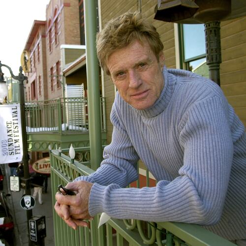 FILE - Robert Redford poses on a balcony along Main Street decorated with his Sundance Film Festival banners on Jan. 17, 2003, in Park City, Utah. (AP Photo/Douglas C. Pizac, File)