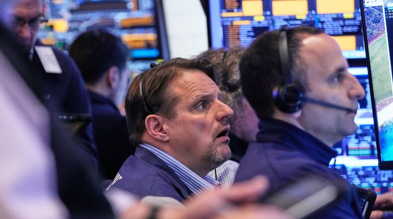 Trader Michael Milano, center, works with colleagues on the floor of the New York Stock Exchange, Wednesday, May 13, 2026. (AP Photo/Richard Drew)