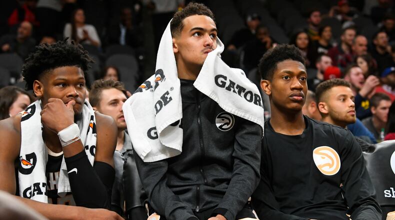 Atlanta Hawks forward Cam Reddish (from left), guard Trae Young and forward De'Andre Hunter watch the final moments of the game against the Detroit Pistons from the bench, Saturday, Jan. 18, 2020, in Atlanta. (John Amis/AP)