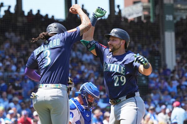 Seattle Mariners' Cal Raleigh, right, celebrates with J.P. Crawford after hitting a two-run home run during the first inning of a baseball game against the Chicago Cubs in Chicago, Sunday, June 22, 2025. (AP Photo/Nam Y. Huh)