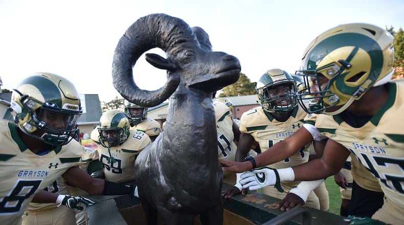 Grayson football players touch their ram statue before a game. HYOSUB SHIN / HSHIN@AJC.COM
