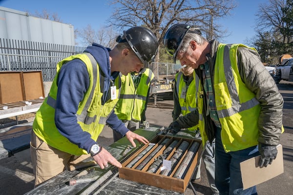 This undated photograph provided by the Denver Museum of Nature and Science shows James Hagadorn, left and Bob Raynolds examining a drilling core from the City Park core drilling in the parking lot at Denver Museum of Nature and Science. (Richard M Wicker/Denver Museum of Nature and Science via AP)