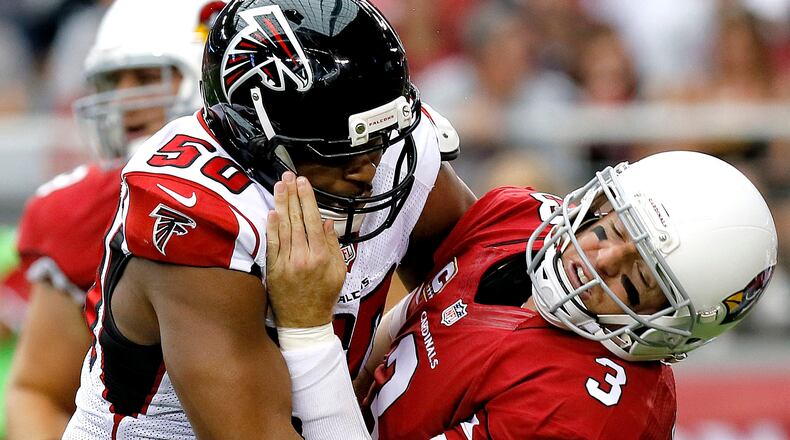 Atlanta Falcons defensive end Osi Umenyiora, left, hits Arizona Cardinals quarterback Carson Palmer late for a penalty during the first half of an NFL football game Sunday, Oct. 27, 2013, in Glendale, Ariz. (AP Photo/Ross D. Franklin)