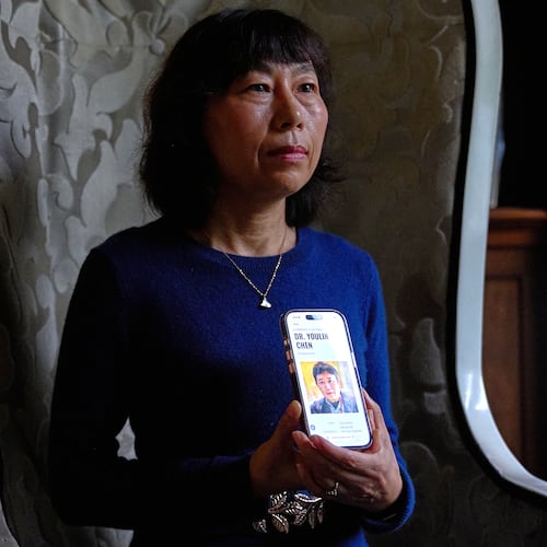 Yufang Rong, wife of U.S. citizen Youlin Chen, who she says has been wrongfully detained in China, holds a photograph of him as seen on a website about detainees on her phone, during an interview, Tuesday, Sept. 22, 2026, in Washington. (AP Photo/Jacquelyn Martin)