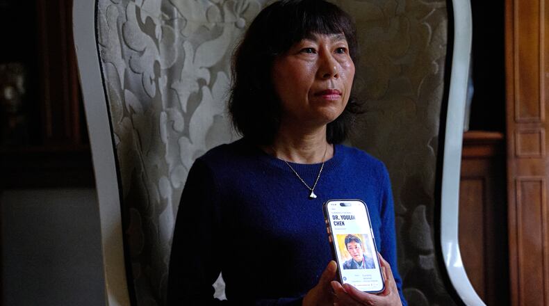 Yufang Rong, wife of U.S. citizen Youlin Chen, who she says has been wrongfully detained in China, holds a photograph of him as seen on a website about detainees on her phone, during an interview, Tuesday, Sept. 22, 2026, in Washington. (AP Photo/Jacquelyn Martin)
