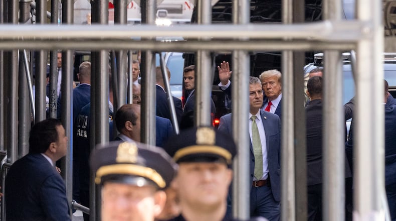 Former President Donald Trump waves as he arrives at the Manhattan Criminal Courthouse in Manhattan, April 4, 2023. The former president is expected to appear today in a Manhattan courtroom and plead not guilty to charges related to his role in a hush-money payment to a porn star in the last days of the 2016 presidential campaign. (Benjamin Norman/The New York Times)