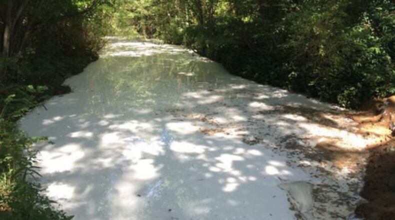 This Cobb County creek water turned white Saturday after 2,300 gallons of a solvent spilled into it. (Credit: Channel 2 Action News)