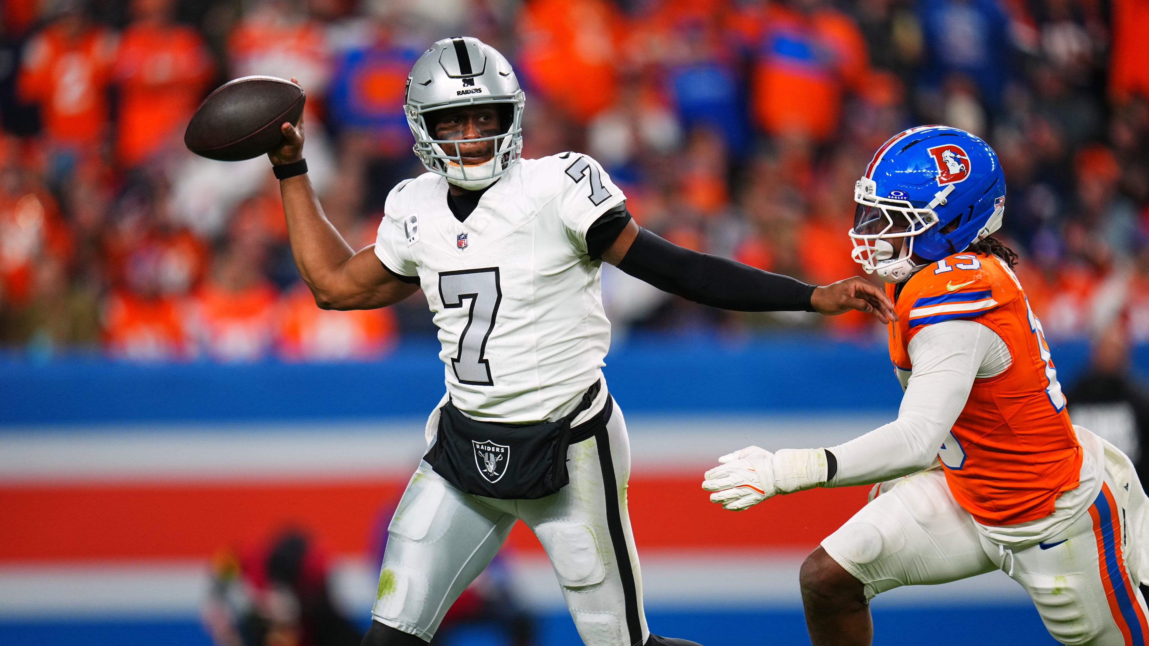 Las Vegas Raiders quarterback Geno Smith (7) throws under pressure from Denver Broncos outside linebacker Nik Bonitto (15) during the second half of an NFL football game Thursday, Nov. 6, 2025, in Denver. (AP Photo/Jack Dempsey)