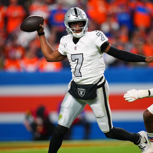 Las Vegas Raiders quarterback Geno Smith (7) throws under pressure from Denver Broncos outside linebacker Nik Bonitto (15) during the second half of an NFL football game Thursday, Nov. 6, 2025, in Denver. (AP Photo/Jack Dempsey)