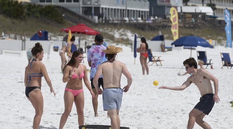 A group of spring breakers play spike ball on the beach in Destin, Fla., on Wednesday, March 18, 2020. But Atlantans can’t look forward to such fun because Okaloosa County officials voted this week to close the beaches. DEVON RAVINE / NORTHWEST FLORIDA DAILY NEWS VIA AP
