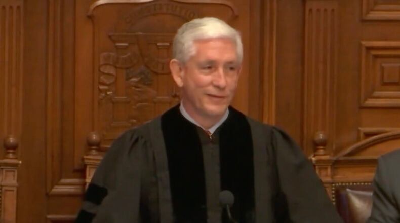 white man in black gown with short white hair.