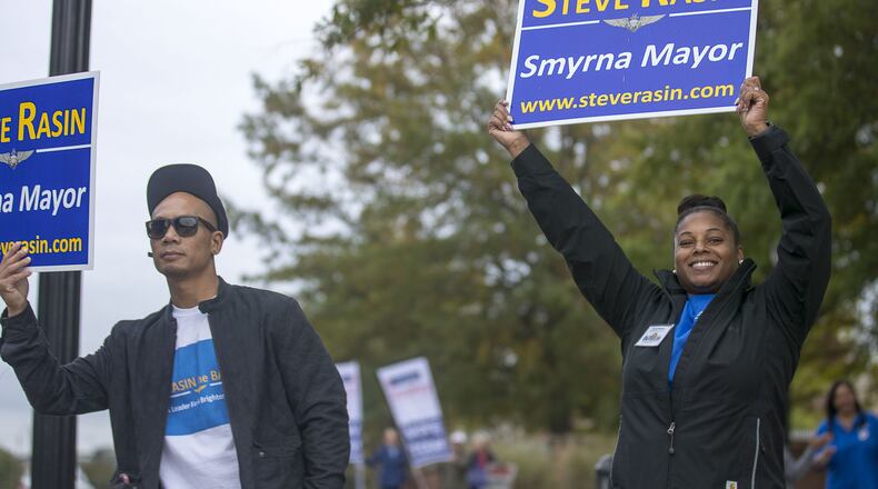 Shayna Rasin (right) and her husband Ramsis Saniatan (left) campaign for Shayna’s father, Smyrna mayoral candidate Steve Rasin, near the Smyrna Comminy Center polling place during Election Day in Smyrna, Tuesday, November 5, 2019. (Alyssa Pointer/Atlanta Journal Constitution)