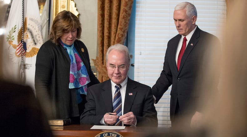 Health and Human Services Secretary Tom Price, center, accompanied by his wife Betty, and Vice President Mike Pence, signs an official document during a swearing in ceremony, Friday, Feb. 10, 2017, in the in the Eisenhower Executive Office Building on the White House complex in Washington. (AP Photo/Andrew Harnik)