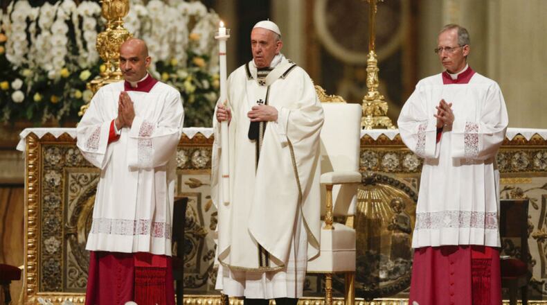 Pope Francis holds a candle as he presides over a solemn Easter vigil ceremony in St. Peter's Basilica at the Vatican, Saturday, April 21, 2019. (AP Photo/Gregorio Borgia)