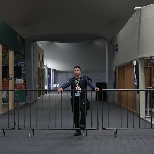 A member of security stands guard near the pavilion section of the COP30 U.N. Climate Summit as it remains closed following a fire earlier in the day, Thursday, Nov. 20, 2025, in Belem, Brazil. (AP Photo/Joshua A. Bickel)